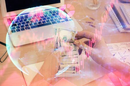 Multi exposure of financial theme drawing hologram and USA dollars bills and man hands. Business concept.の写真素材
