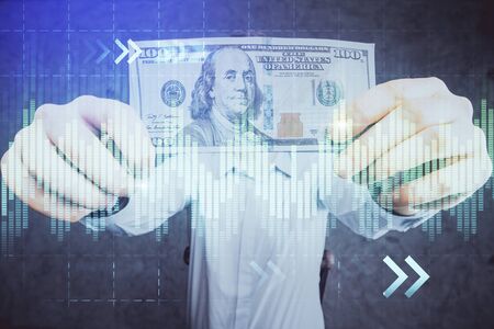 Multi exposure of financial graph drawing hologram and USA dollars bills and man hands. Analysis concept.の写真素材