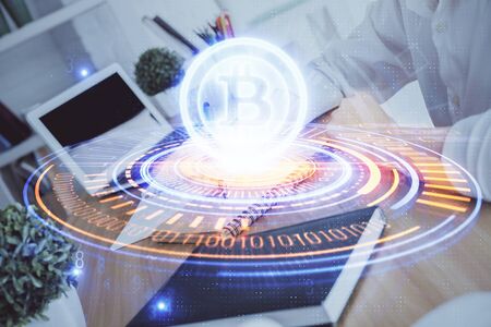 Cryptocurrency hologram over hands taking notes background. Concept of blockchain. Multi exposureの写真素材