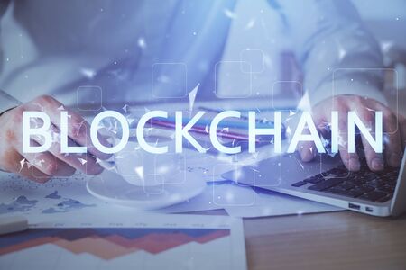 Crypto currency theme hologram with businessman working on computer on background. Concept of...