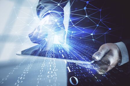Double exposure of man's hand holding and using a digital device and data theme hologram drawing....