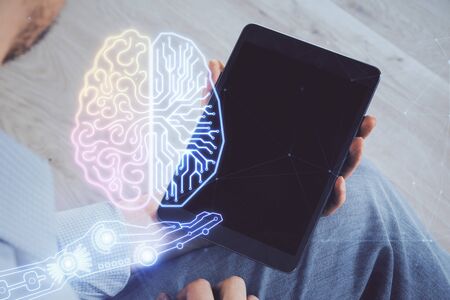 Double exposure of mans hand holding and using a digital device and brain hologram drawing. Data concept.の写真素材