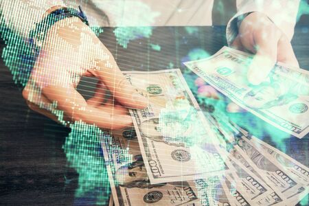 Multi exposure of financial theme drawing hologram and USA dollars bills and man hands. Business concept.の写真素材