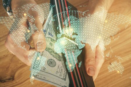 Multi exposure of financial theme drawing hologram and USA dollars bills and man hands. Business...