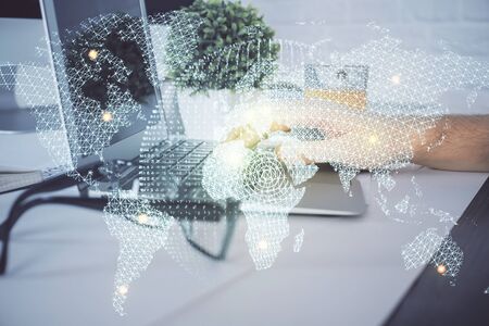 Double exposure of businessman working on laptop on background. International business hologram in front. Concept of success.の写真素材