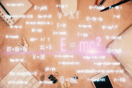 Double exposure of formula drawing over table with phone. Top view. Education concept.の写真素材