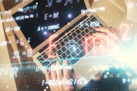 Double exposure of woman hands working on computer and formula hologram drawing. Top View. Science concept.の写真素材