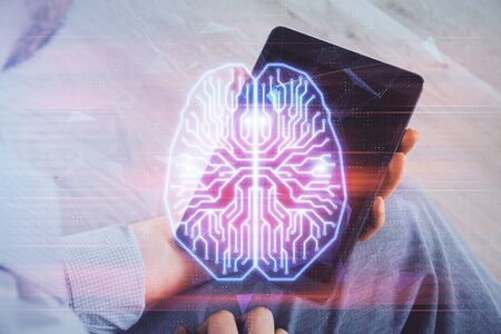 Double exposure of man's hand holding and using a digital device and brain hologram drawing. Data concept.の写真素材