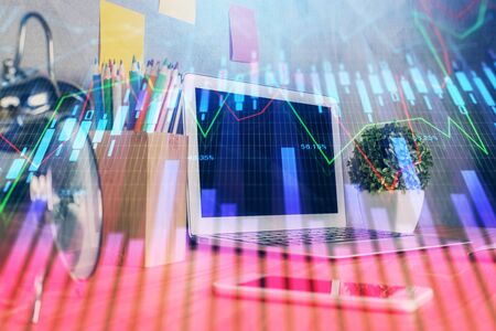 Financial market graph hologram and personal computer on background. Multi exposure. Concept of forex.の写真素材