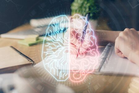 Multi exposure of writing hand on background with brain hologram. Concept of self learning.の写真素材