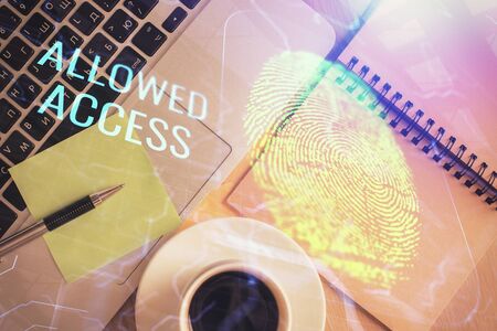 Finger print over computer on the desktop background. Top view. Double exposure. Concept of...