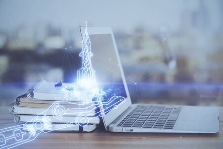 Desktop computer background in office and start up theme hologram drawing. Double exposure. Startup concept.の写真素材