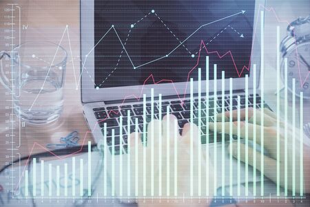 Multi exposure of market chart with man working on computer on background. Concept of financial analysis.の写真素材