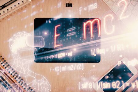 Double exposure of formula drawing over table with phone. Top view. Education concept.の写真素材