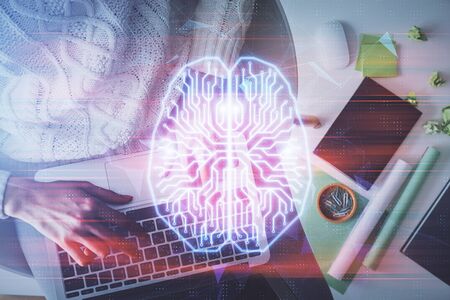 Double exposure of woman working on computer andhuman brain hologram drawing. Top View. Ai concept.