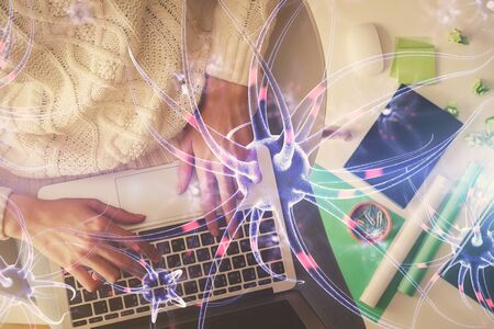 Double exposure of woman hands working on computer and neuron hologram drawing. Top View. Science...