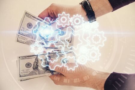 Multi exposure of financial theme drawing hologram and USA dollars bills and man hands. Business...