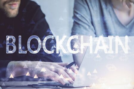 Crypto currency theme hologram with businessman working on computer on background. Concept of blockchain. Double exposure.の写真素材