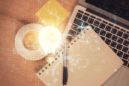 Bulb drawing over computer on the desktop background. Top view. Double exposure. Idea concept.の写真素材