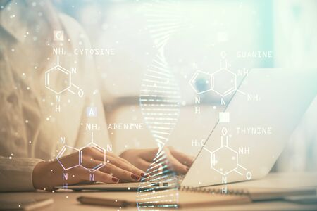 Double exposure of woman hands typing on computer and DNA hologram drawing. Medical education concept.の写真素材
