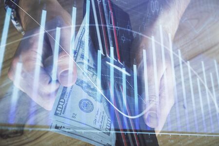 Multi exposure of forex graph drawing hologram and USA dollars bills and man hands. Technical...