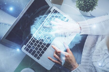 Double exposure of woman working on computer andhuman brain hologram drawing. Top View. Ai concept.の写真素材