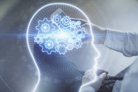 Double exposure of man's hand holding and using a digital device and brain hologram drawing. Data concept.の写真素材