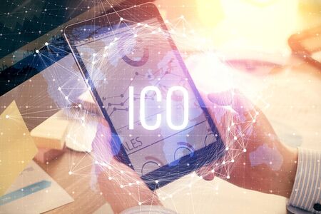 Double exposure of mans hands holding and using a phone and crypto currency blockchain theme...