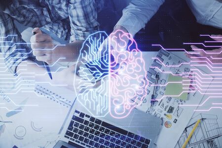 Double exposure of man and woman working together holding and using a mobile device and brain hologram drawing.の写真素材