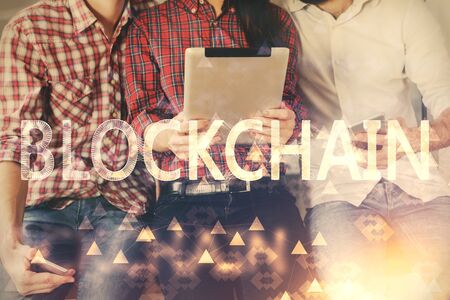 Double exposure of crypto theme drawing and man and woman working together holding and using a mobile device. Blockchain concept.の写真素材