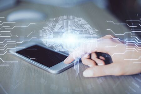 Double exposure of brain sketch hologram and woman holding and using a mobile device.