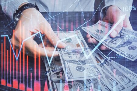 Multi exposure of financial graph drawing hologram and USA dollars bills and man hands. Analysis...