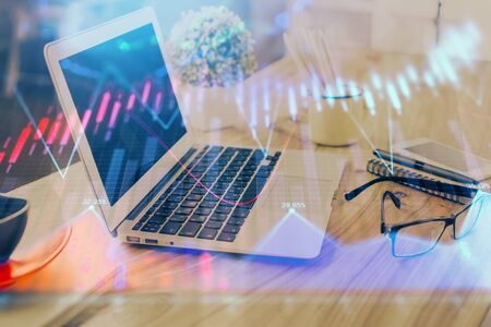 Forex market chart hologram and personal computer background. Double exposure. Concept of investment.の写真素材