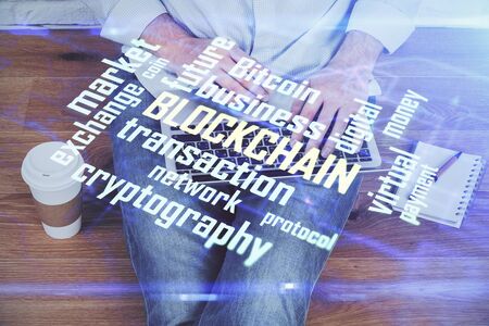 Crypto currency theme hologram with businessman working on computer on background. Concept of...