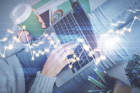 Double exposure of woman hands typing on computer and forex chart hologram drawing. Stock market...
