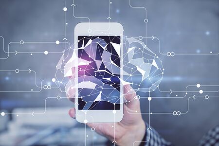 Double exposure of man's hand holding and using a digital device and brain hologram drawing. Data...