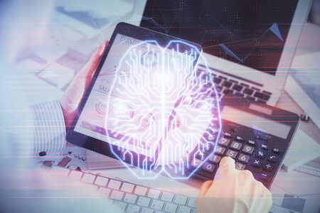 Double exposure of man's hand holding and using a digital device and brain hologram drawing. Data...