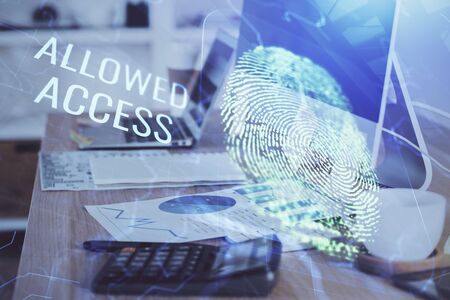 Computer on desktop in office with finger print drawing. Double exposure. Concept of business data security.の写真素材