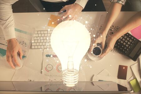 Double exposure of man and woman working together and bulb drawing. Computer background. Top View. Idea concept.の写真素材