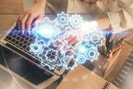 Double exposure of woman hands typing on computer and business theme hologram drawing. Success...