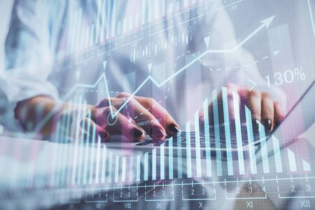 Double exposure of woman hands typing on computer and forex chart hologram drawing. Stock market...