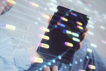 Double exposure of mans hand holding and using a digital device and data theme drawing. Technology...