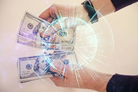 Multi exposure of financial theme drawing hologram and USA dollars bills and man hands. Business concept.の写真素材