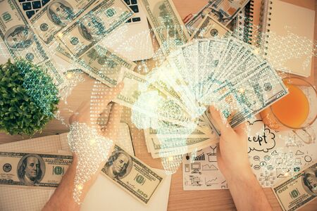Multi exposure of financial theme drawing hologram and USA dollars bills and man hands. Business concept.の写真素材