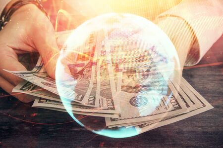 Multi exposure of financial theme drawing hologram and USA dollars bills and man hands. Business concept.の写真素材