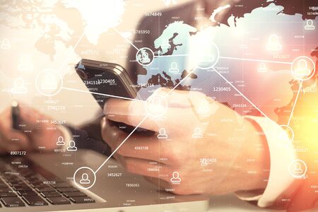 Double exposure of mans hands holding and using a phone and social network theme drawing.