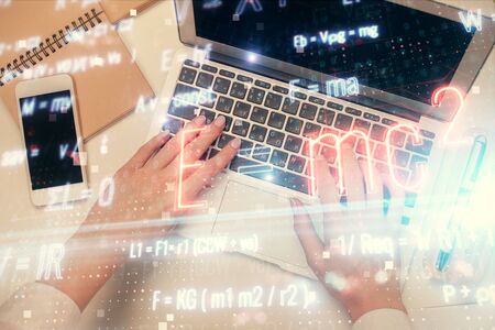 Double exposure of woman hands working on computer and formula hologram drawing. Top View. Science...