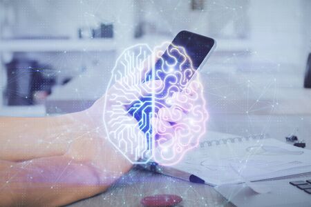 Double exposure of mans hand holding and using a digital device and brain hologram drawing. Data...