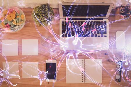 Neuron hologram drawings over computer on the desktop background. Top view. Multi exposure. Concept...