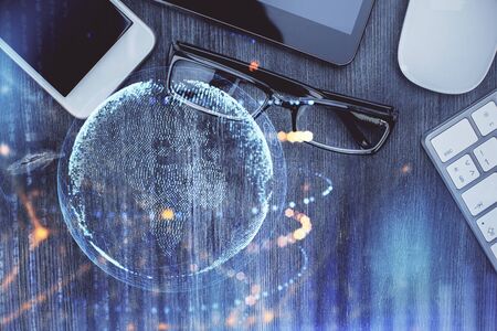 Double exposure of map hologram drawing over desktop. Top view. International connection concept.の写真素材